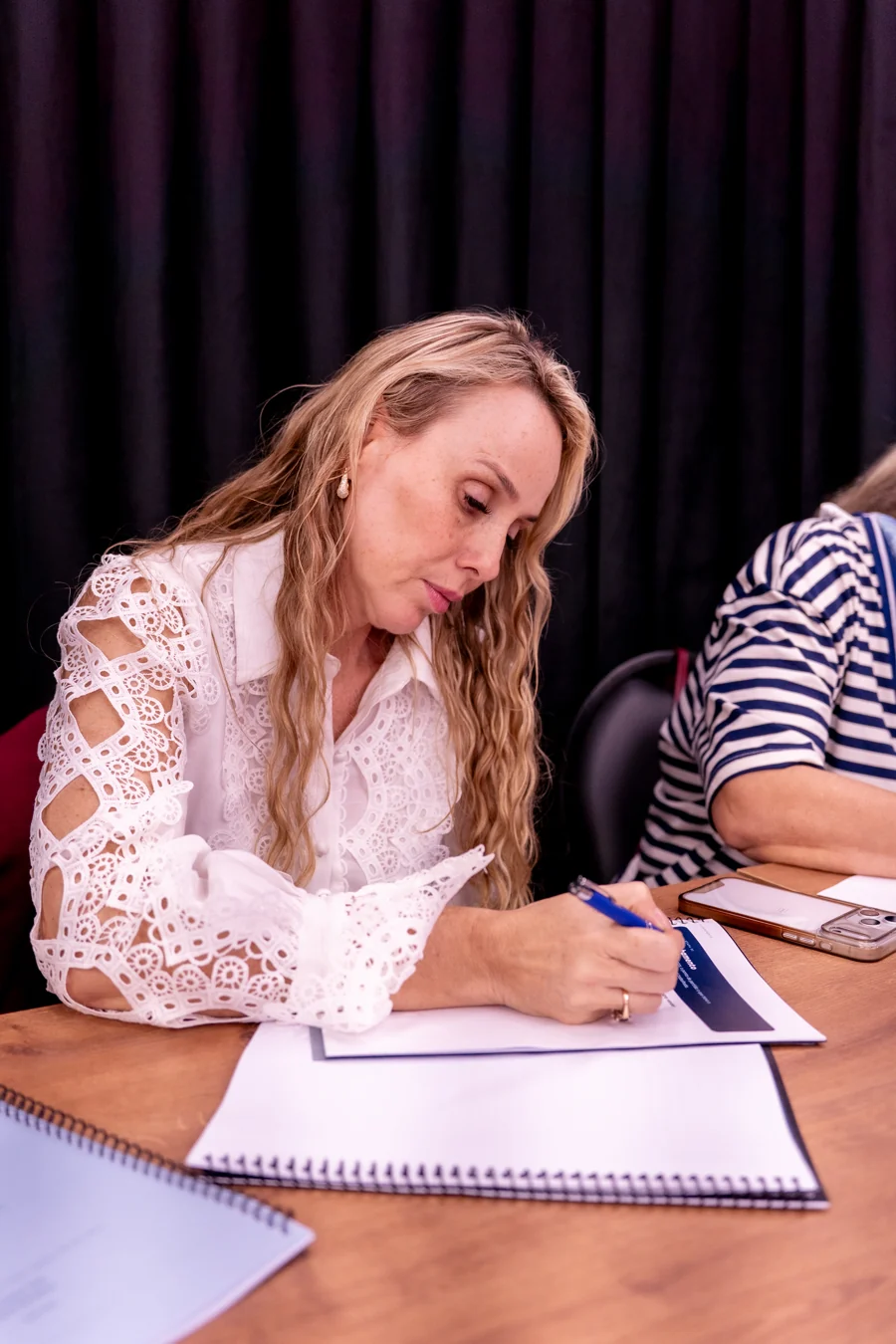 Participante fazendo anotações no caderno durante a oficina presencial